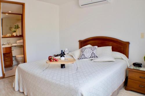 a bedroom with a bed with a tray of fruit on it at Portal del Rodeo ApartaHotel in Medellín