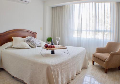 a bedroom with a bed with a table and a chair at Portal del Rodeo ApartaHotel in Medellín