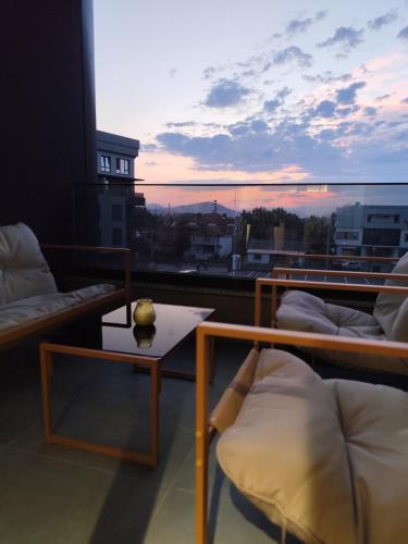 a room with a balcony with a view of a sunset at Sky view N&N in Skopje
