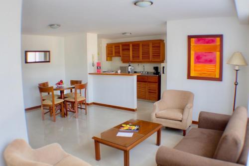a living room with a table and a kitchen at Portal del Rodeo ApartaHotel in Medellín
