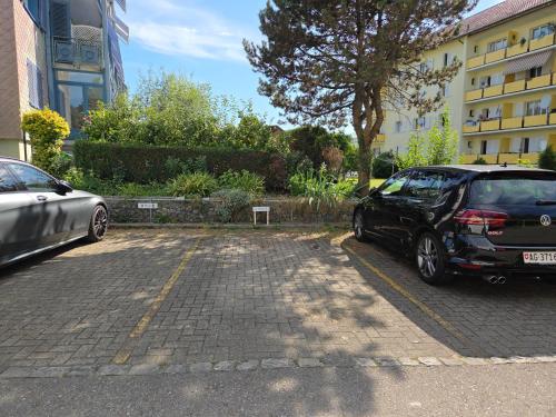 two cars parked in a parking lot next to a building at Apartment for 5, close to Zurich and Luzern, free private parking in Wohlen