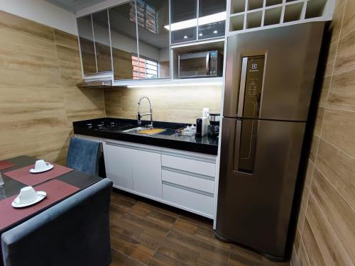 uma cozinha com uma geladeira de aço inoxidável e uma mesa em Apartamento Inteiro - Casa Nostra Guest House 1 - Nomad Ready em Belém