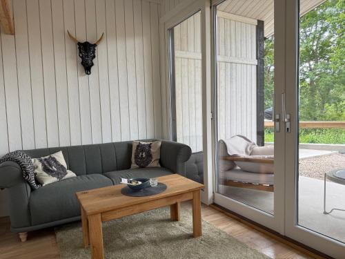 a living room with a couch and a table at Hällesdalens Gård - semesterhus i Bohuslän in Svenshögen
