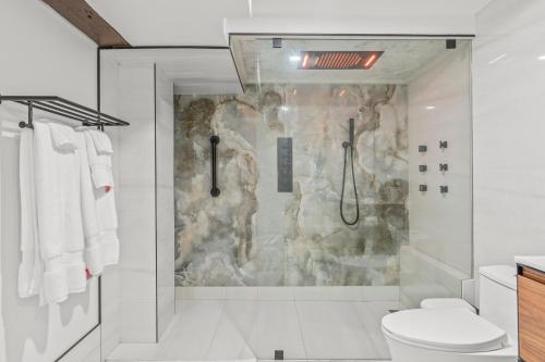 a bathroom with a shower with a stone wall at Blue Spruce Den - Vernon in Vernon