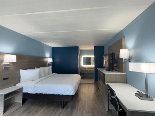 a hotel room with a bed and a tv at SureStay by Best Western Jacksonville Airport in Jacksonville