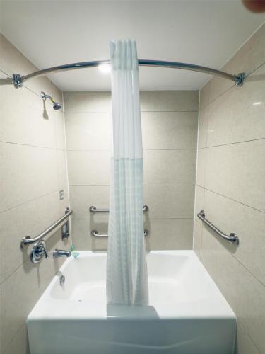 a bathroom with a shower curtain and a sink at SureStay by Best Western Jacksonville Airport in Jacksonville