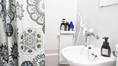 a bathroom with a shower curtain and a sink at MIYAVI#303 3min walk Narimasu Station, 4 people, wide queen bed & sofa, Tokyo's largest Don Quijote in Tokyo