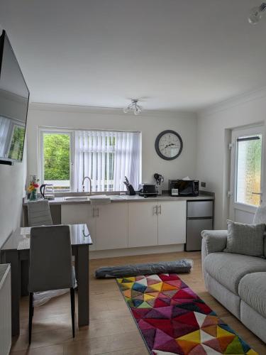a kitchen and living room with a couch and a table at Pinecroft in Pembrokeshire