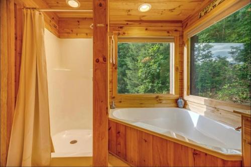 a bathroom with a tub and a window at 4 Bed 4 Bath Vacation home in Sylva in Sylva