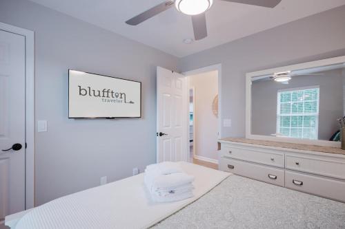 a white bedroom with a bed and a mirror at Lowcountry Lodge in Bluffton