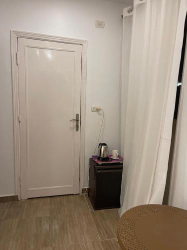 a white door in a room with a table and a lamp at Farida Pyramids ŌTEL in Cairo