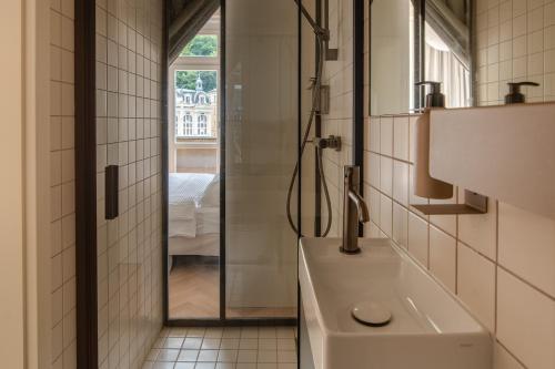 un baño con lavabo y espejo en Limewash Apartments Karlsbad, en Karlovy Vary