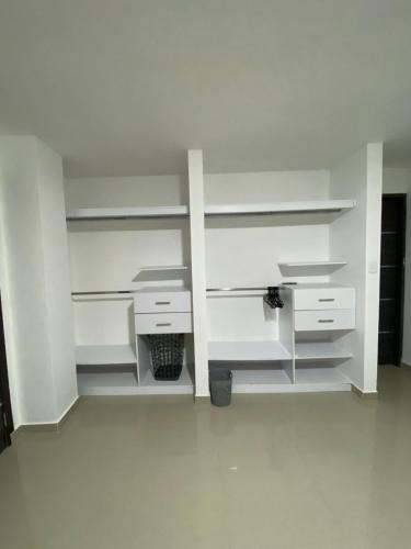 an empty room with white shelves and white cabinets at Hotel residencial bella vista in Mocoa
