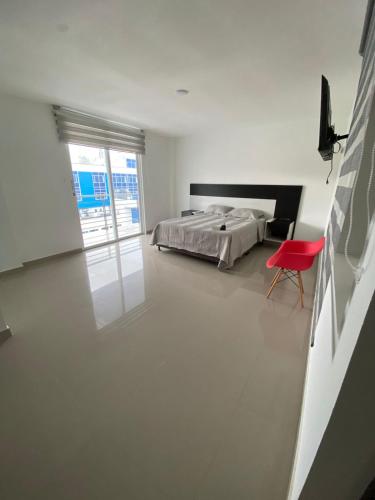 a bedroom with a bed and a red chair at Hotel residencial bella vista in Mocoa