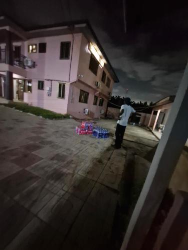 a man standing in front of a building at night at Crystal Rock Hotel in Teiman