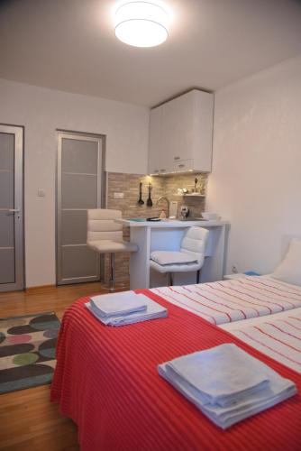a room with two beds and a kitchen with a counter at Dekart 2 in Niš