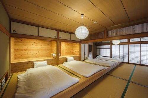 two beds in a large room with wooden walls at Kawashiri no Tomari - Vacation STAY 17885v in Kumamoto