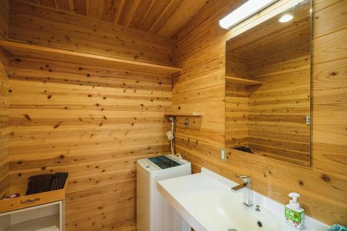 a bathroom with wooden walls and a sink and a washing machine at Kawashiri no Tomari - Vacation STAY 17885v in Kumamoto