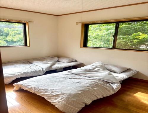 deux lits dans une chambre avec deux fenêtres dans l'établissement Biwako Hills - Vacation STAY 04132v, à Takashima
