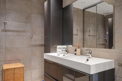 a bathroom with a white sink and a mirror at Fagertoppen 1314B by Vacation Trysil in Mælem