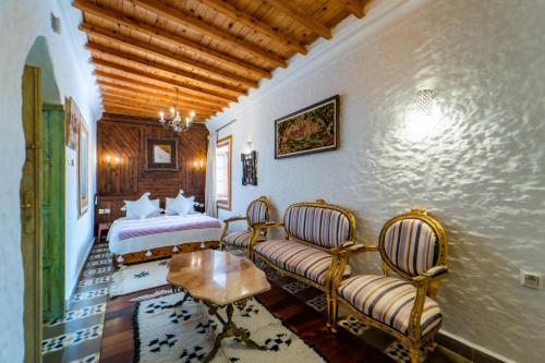 a bedroom with a bed and a couch and a table at RIAD LA SANTA in Chefchaouene