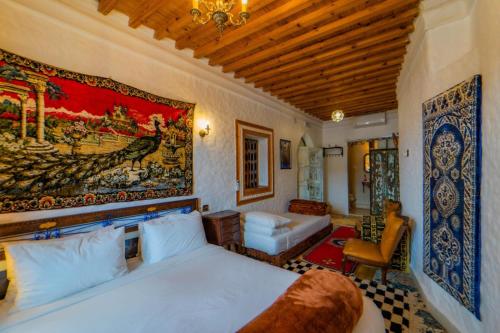 a bedroom with a bed and a painting on the wall at RIAD LA SANTA in Chefchaouene