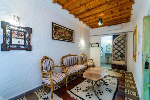 a living room with two chairs and a table at RIAD LA SANTA in Chefchaouene