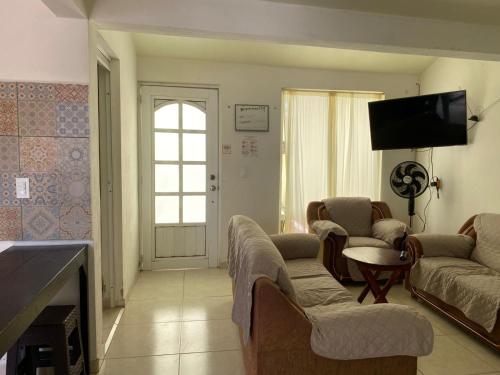 a living room with couches and a flat screen tv at Casa 18 de Marzo, Tulancingo in Tulancingo