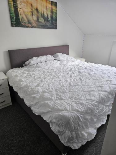 a bed with a white comforter in a bedroom at Northampton RoomKey in Northampton