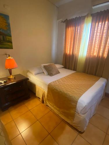 a bedroom with two beds and a lamp and a window at Hostal Fuente Castalia, B y B in León