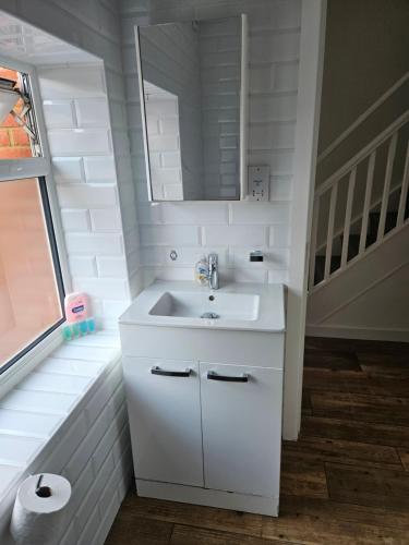 a bathroom with a white sink and a mirror at Northampton RoomKey in Northampton