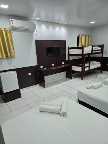 a room with two beds and a flat screen tv at New Center Hotel in Carolina