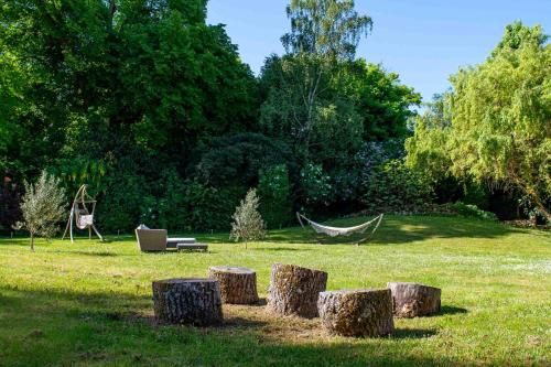 a group of logs sitting in a field with a hammock at Marquise Barbot in Evry-Courcouronnes