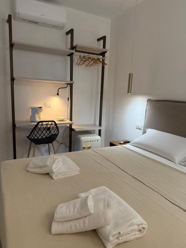 a bedroom with a bed with a towel on it at Mariposa Rooms in San Teodoro