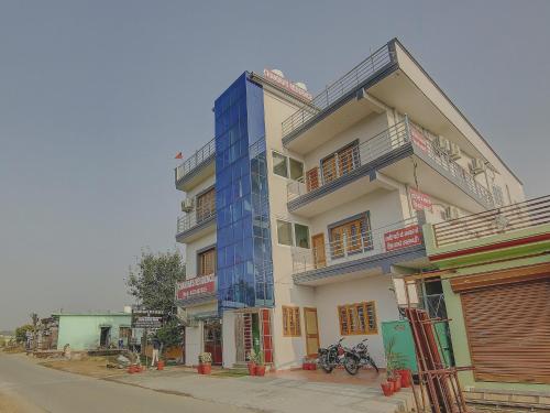 a tall building with a blue facade on a street at SPOT ON Chandra's Residence in Dehradun