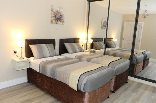 two beds in a room with two mirrors at Coaches Corner - Accessible Self-Catering Guest Suite - 5 Minutes from town - Singles or Super-King in Castleblayney