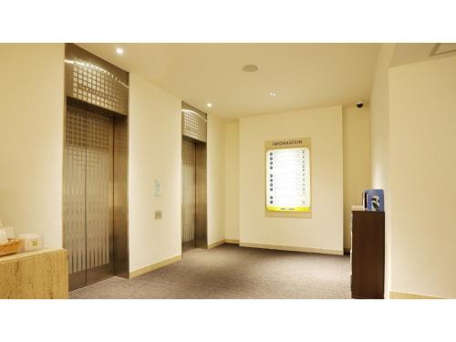 a hallway with two doors and a window at Smile Hotel Kumagaya - Vacation STAY 90020v in Kumagaya