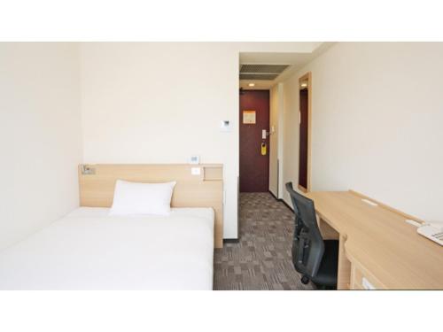 a hotel room with a bed and a desk with a monitor at Smile Hotel Kumagaya - Vacation STAY 89997v in Kumagaya