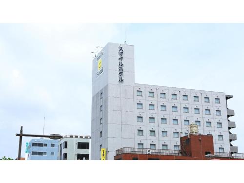 a white building with a sign on top of it at Smile Hotel Kumagaya - Vacation STAY 90811v in Kumagaya