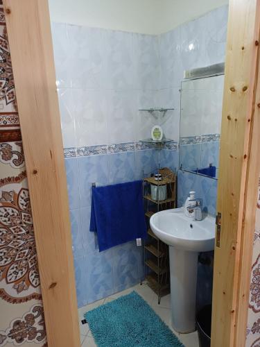 a blue tiled bathroom with a sink and a mirror at Spacious Apartment Casablanca in Casablanca