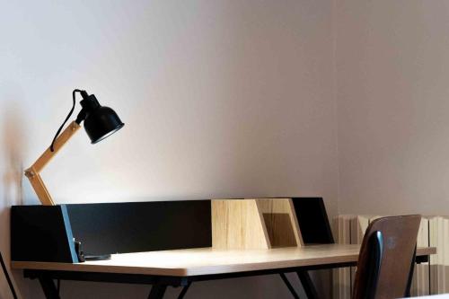 a desk with a lamp and a table with chairs at Marquise Barbot in Evry-Courcouronnes