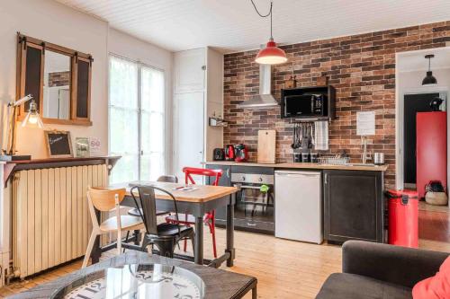 a kitchen and living room with a table and chairs at Marquise Barbot in Evry-Courcouronnes