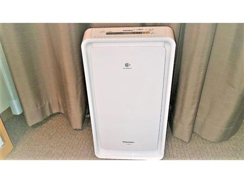 a white cell phone sitting in front of a curtain at Smile Hotel Shimonoseki - Vacation STAY 96740v in Shimonoseki