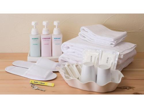 ein Tablett mit mehreren Flaschen und Handtüchern auf einem Tisch in der Unterkunft Smile Hotel Shizuoka - Vacation STAY 76993v in Shizuoka