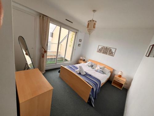 a bedroom with a bed and a large window at Vue mer exceptionnelle-Appartement cosy à Erquy in Erquy