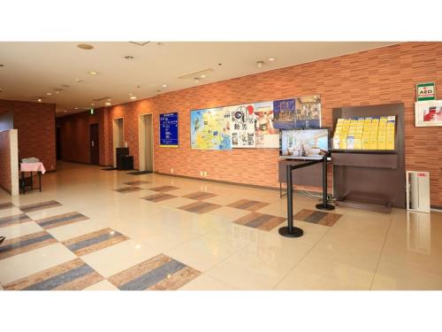 a lobby with a tile floor and a brick wall at Smile Hotel Shimonoseki - Vacation STAY 96720v in Shimonoseki