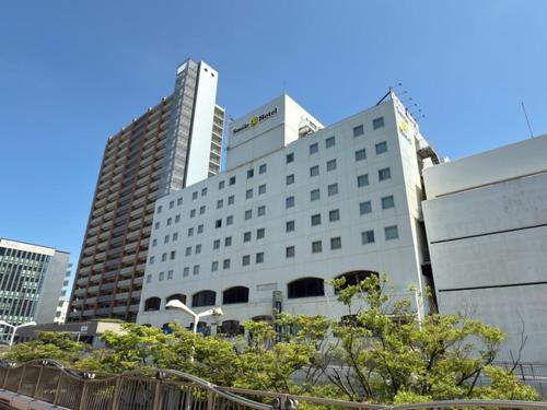 a large white building with two tall buildings at Smile Hotel Shimonoseki - Vacation STAY 96720v in Shimonoseki