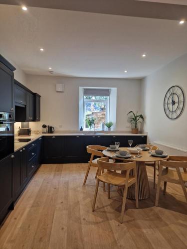 a kitchen and dining room with a table and chairs at City Residence Free Parking in Stirling
