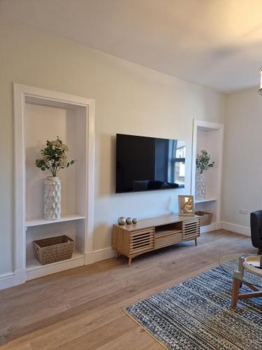 a living room with a flat screen tv on a wall at City Residence Free Parking in Stirling