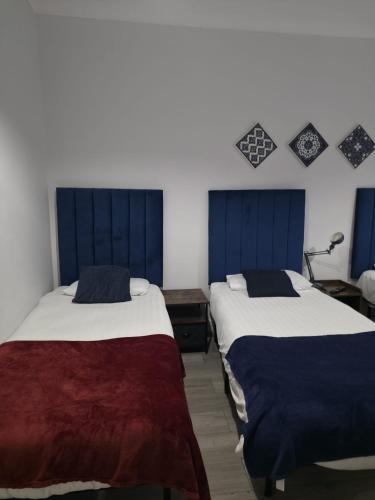 two beds in a room with blue and white at Golders Park Hotel in London